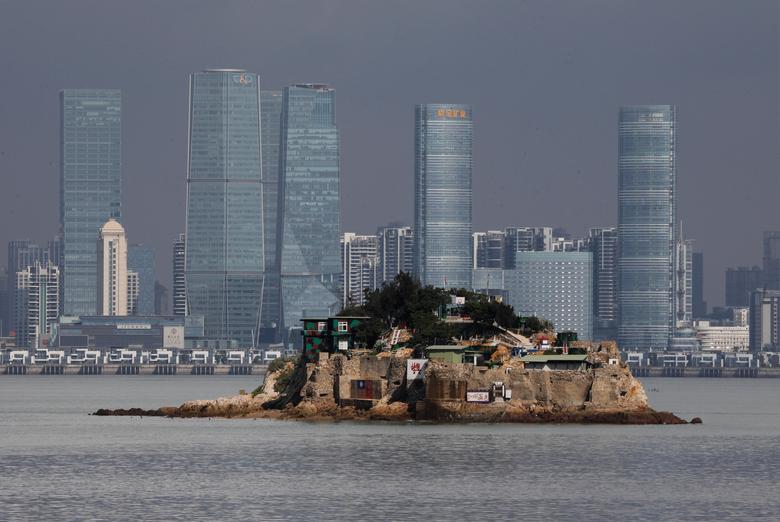 A view of Taiwan’s Shi Islet with the skyline of Xiamen’s skyline in the background, a bustling economy