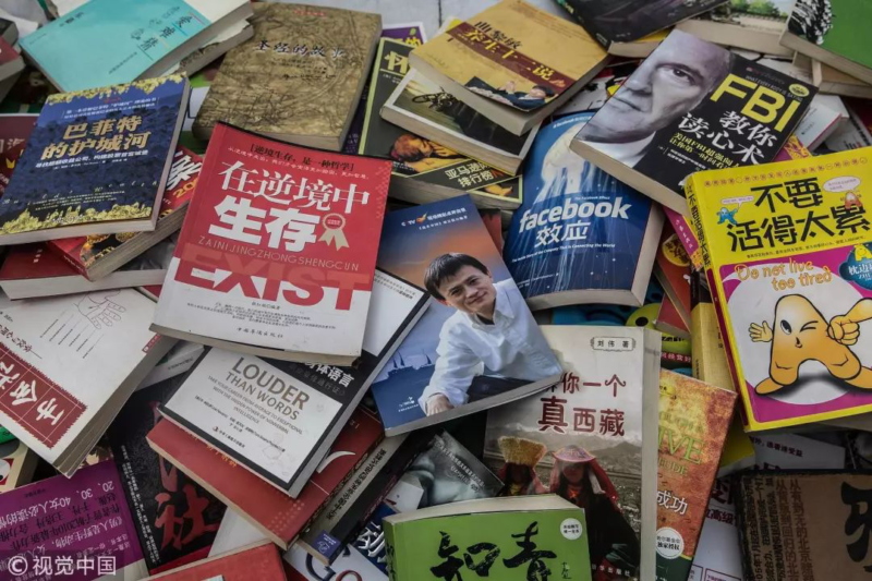 Visual China Group, Photo taken from a street vendor selling stack of books on success stories, career advancement and personal development. 