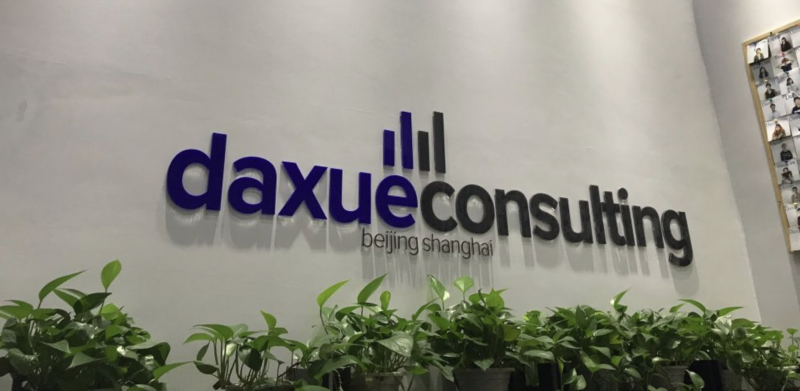 Daxue Consulting logo on the office wall, with the Beijing and Shanghai offices named under it